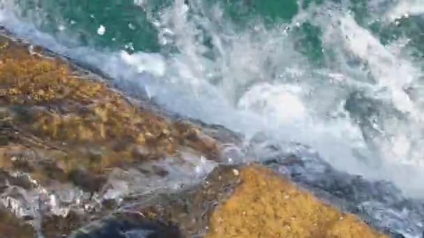 As ondas lavaram-se sobre as rochas na costa. Superfície de água clara azul Videoclipe