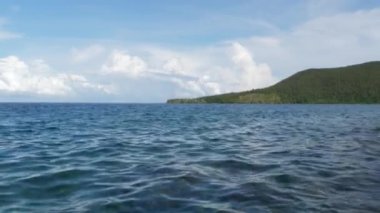 Sakin denizde küçük dalgalar. Denizin yüzeyi çok pürüzsüzdür. Mavi berrak su yüzeyi.