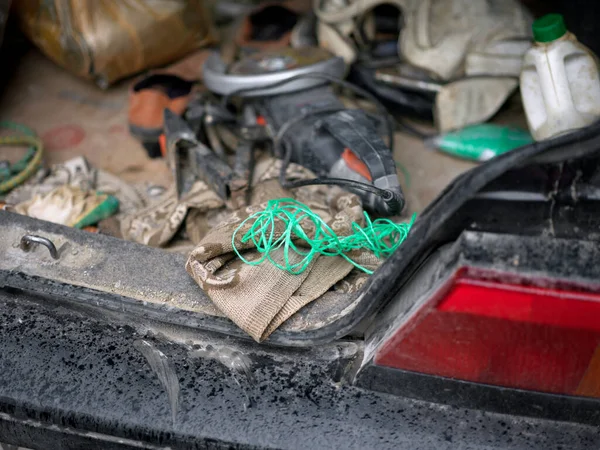 Open messy car trunk with handtools, outdoor closeup