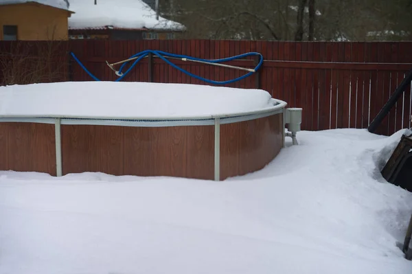 Above ground swimming pool completely under snow, winter scene