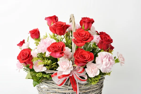 Rosas rojas y claveles rosas en una canasta —  Fotos de Stock