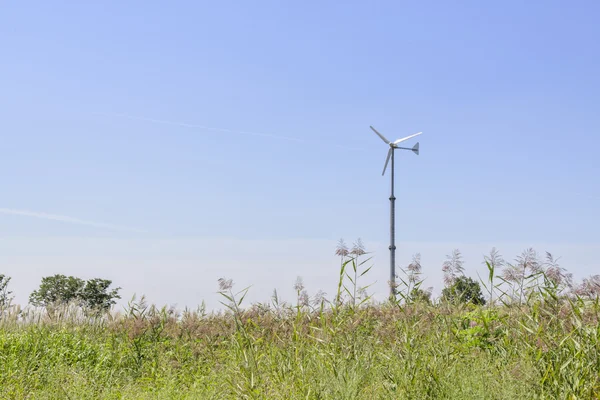 Stříbrný travnaté hřiště s větrné elektrárny generátor — Stock fotografie