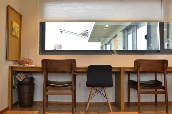 Стулья и письменный стол перед окнами — стоковое фото