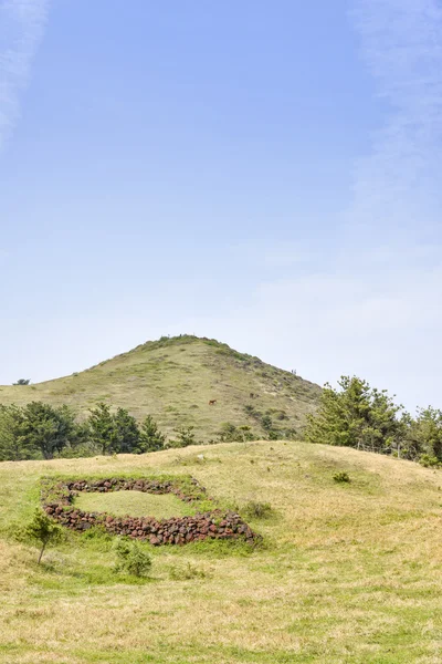 Landscape of Songaksan mountain with Jeju traditional tomb — Stok fotoğraf