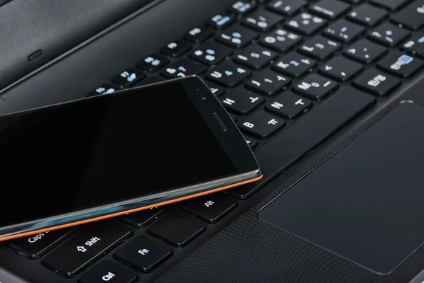 Smartphone on a keypad of laptop — Stock Photo, Image
