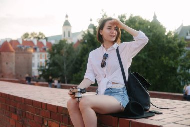 Eski bir Avrupa şehrinde kamerası olan genç bir hippi kız. Kız seyahat ediyor.