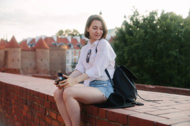 Eski bir Avrupa şehrinde kamerası olan genç bir hippi kız. Kız seyahat ediyor.