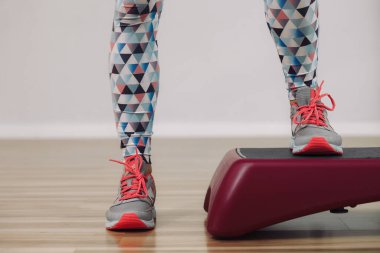 Genç bir kadın platformda dikiliyor. Yakın plan bacak fotoğrafı.