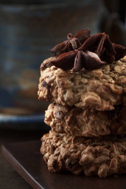 Mavi tabakta kurabiyeler, etrafa saçılmış baharatlar. Arka plan karanlık.