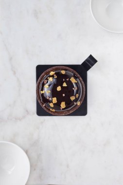 Çikolatalı pasta ve beyaz mermer bir tahtada iki beyaz kase..