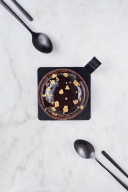 Çikolatalı pasta ve dört tatlı kaşığı beyaz mermer tahtada.