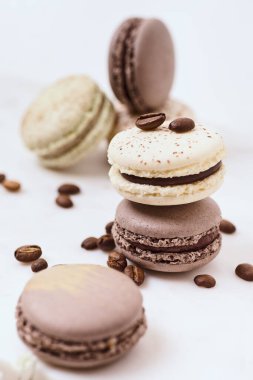 Beyaz arka planda birkaç renkli makaron ve kahve çekirdeği.