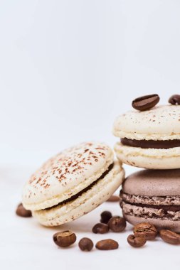 Beyaz arka planda birkaç renkli makaron ve kahve çekirdeği.