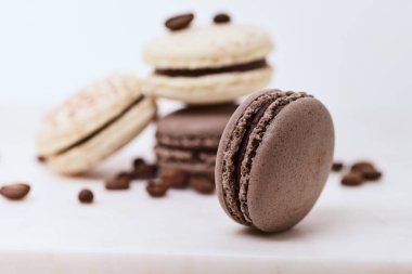 Beyaz arka planda birkaç renkli makaron ve kahve çekirdeği.