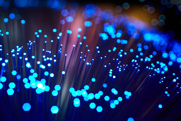 glowing fiber optic strings on color background