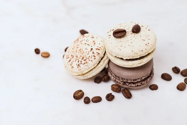 Wenige Farbige Macarons Und Kaffeebohnen Auf Weißem Hintergrund — Stockfoto