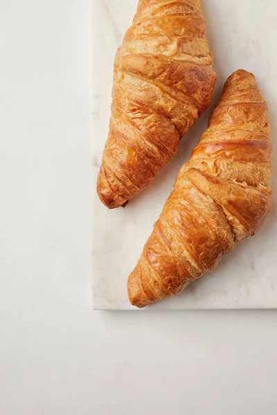 Croissants en el tablero de mármol blanco — Foto de Stock