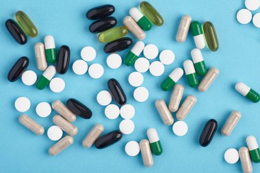 Beyaz pil ve renkli kapsüllerin yakınlaştırılması. İlaç yığını - tıbbi geçmiş