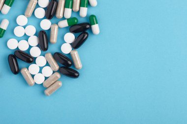 Beyaz pil ve renkli kapsüllerin yakınlaştırılması. İlaç yığını - tıbbi geçmiş