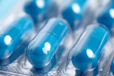 Bir paket mavi ilaç hapı. Fotoğrafı kapat.