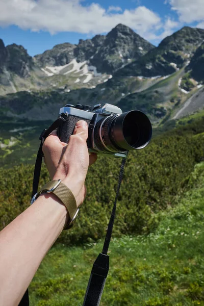 Vintage camera film camera on the background of mountains landscape.
