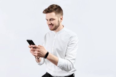 Akıllı telefon kullanan beyaz gömlekli bir adam. İzole edilmiş