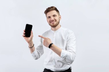 Beyaz gömlekli bir adam akıllı telefon gösteriyor. İzole et
