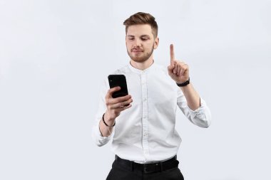 Beyaz tişörtlü bir adam akıllı telefondan kendini gösteriyor. İzole et