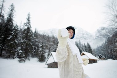 Dağ evlerinin arka planında bir kadın portresi. Kış manzarası