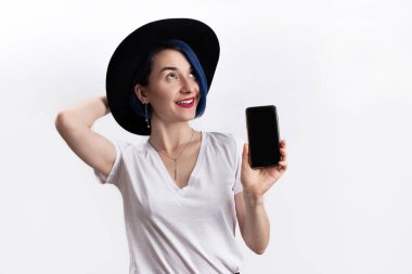 Beyaz tişörtlü bir kadın akıllı telefon görüntüsü veriyor.