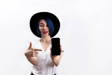 Beyaz tişörtlü bir kadın akıllı telefon görüntüsü veriyor.