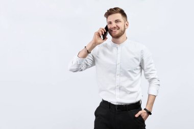 Beyaz gömlekli bir adam telefonla konuşuyor. İzole edilmiş