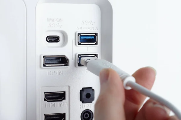 Monitörün USB merkeziyle olan kablo bağlantısına yakın çekim. Elle.