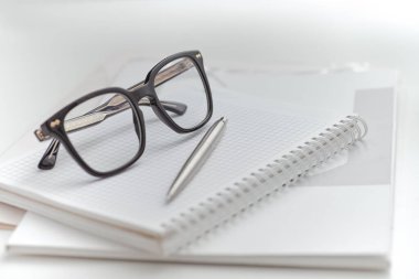 Masasında belgeler olan bir klasörün üzerinde siyah gözlük. Yakın plan.