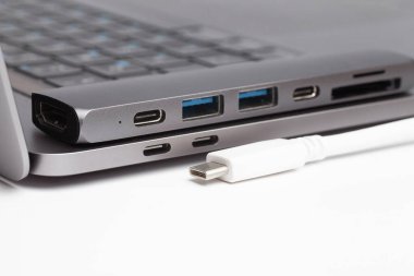 C tipi merkez, beyaz tip c tipi kablo ve dizüstü bilgisayarın yakın plan fotoğrafı