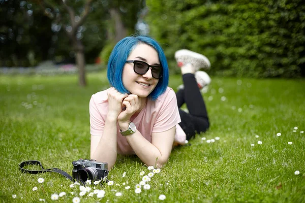 Genç bir gezgin bir Avrupa bahçesindeki çimlerin üzerinde yatıyor. Yaz seyahati