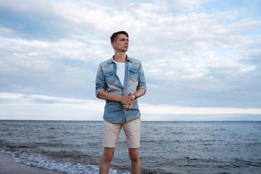 Aktif ve sağlıklı genç erkekler, kumlu bir baltık sahilinin tadını çıkarıyorlar. Yaz tatili