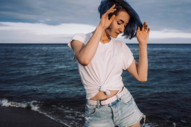 Aktif ve sağlıklı genç bir kadın, kumlu bir baltık plajında eğleniyor. Yaz tatili