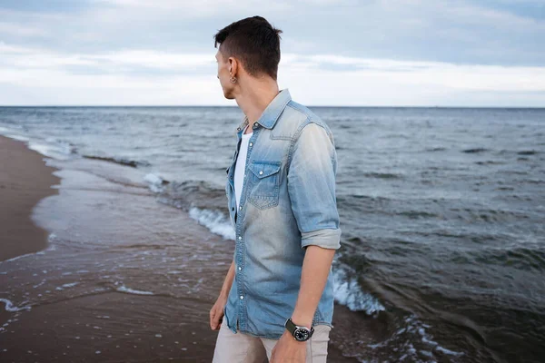 Aktif ve sağlıklı genç erkekler, kumlu bir baltık sahilinin tadını çıkarıyorlar. Yaz tatili