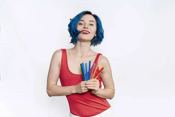 Kırmızı elbiseli bir kadın tasarımcı elinde kalemler tutuyor. Beyaz arkaplan