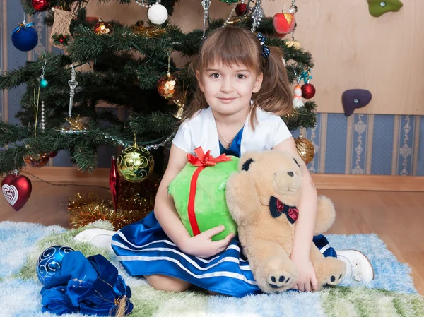 Lachende meisje met Kerstmis geschenken bij kerstboom (6 jaar) — Stockfoto