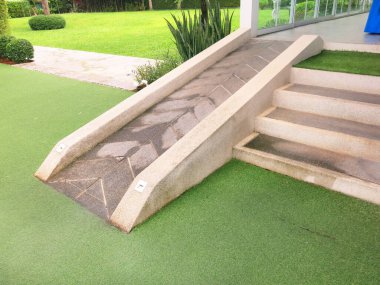 Parkta yeşil çimenler ve taş kaldırım 