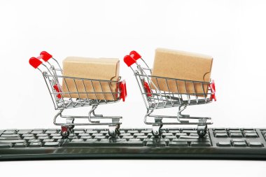 Bilgisayar klavyesinde kutuları olan alışveriş arabaları beyaz arka plan 