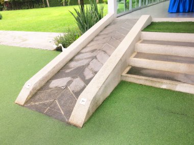 Parkta yeşil çimenler ve taş kaldırım 