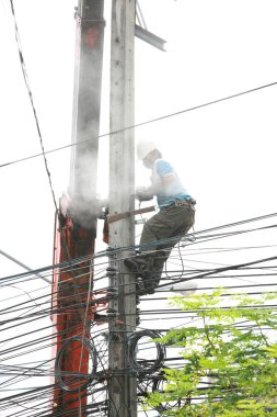 The electricity worker climbing on the tower.