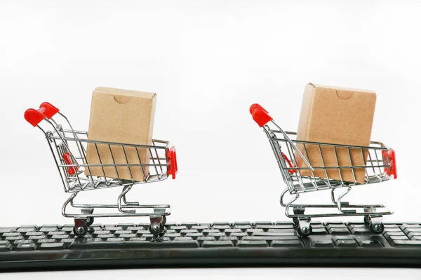 shopping carts with boxes on computer keyboard white background