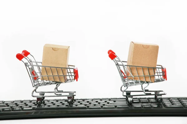 shopping carts with boxes on computer keyboard white background