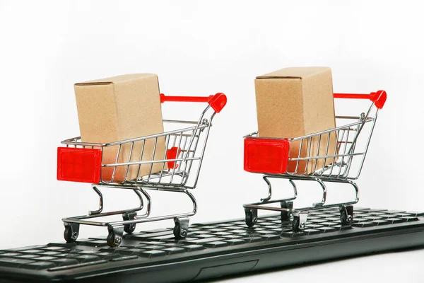 shopping carts with boxes on computer keyboard white background