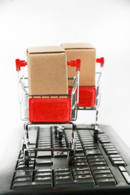 Bilgisayar klavyesinde kutuları olan alışveriş arabaları beyaz arka plan 