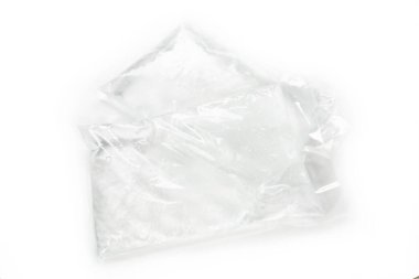 Arkaplanda buruşuk folyo olan beyaz plastik torba.